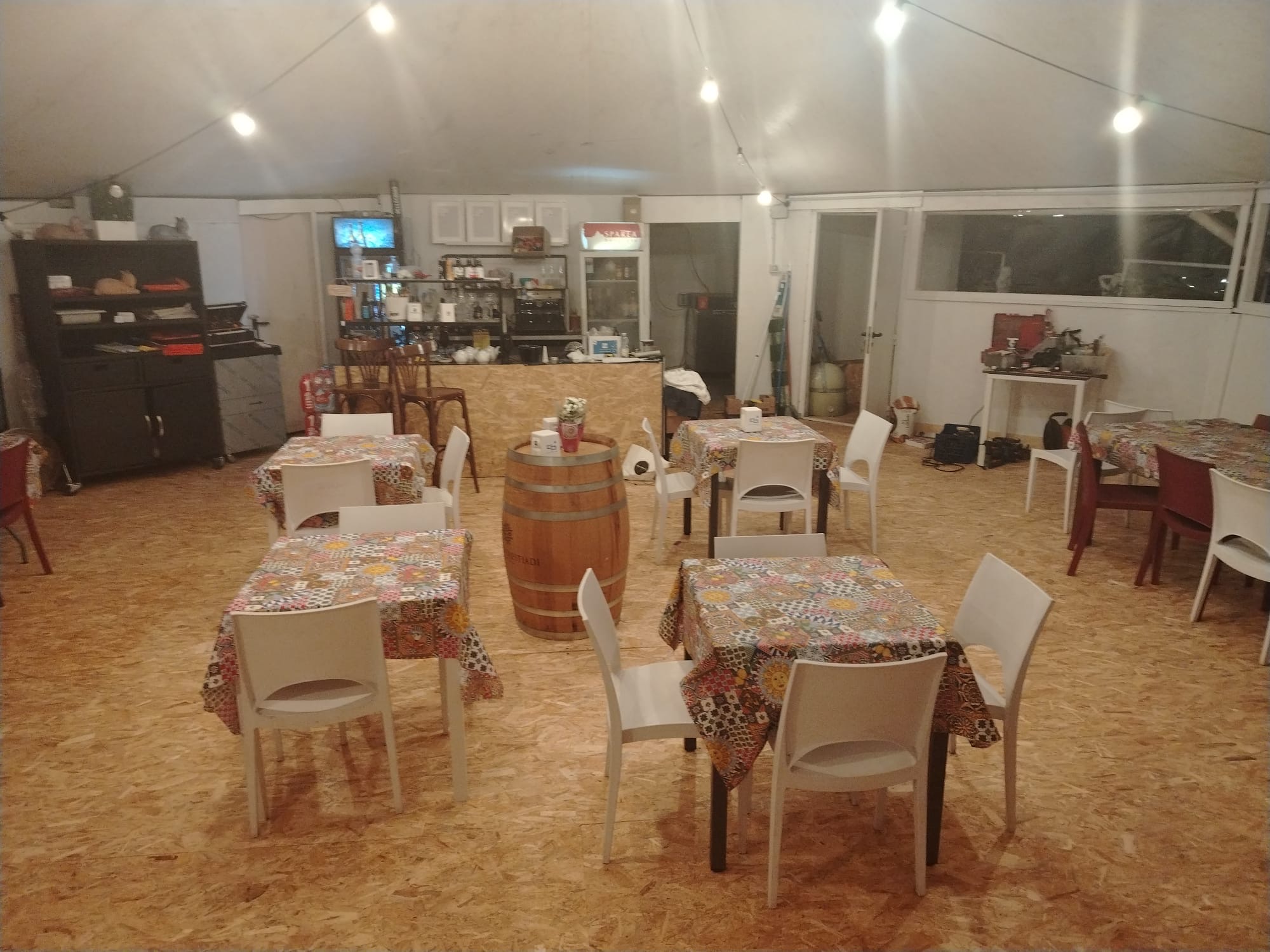 Interno accogliente dell'Osteria Basana con tavoli e botte in legno