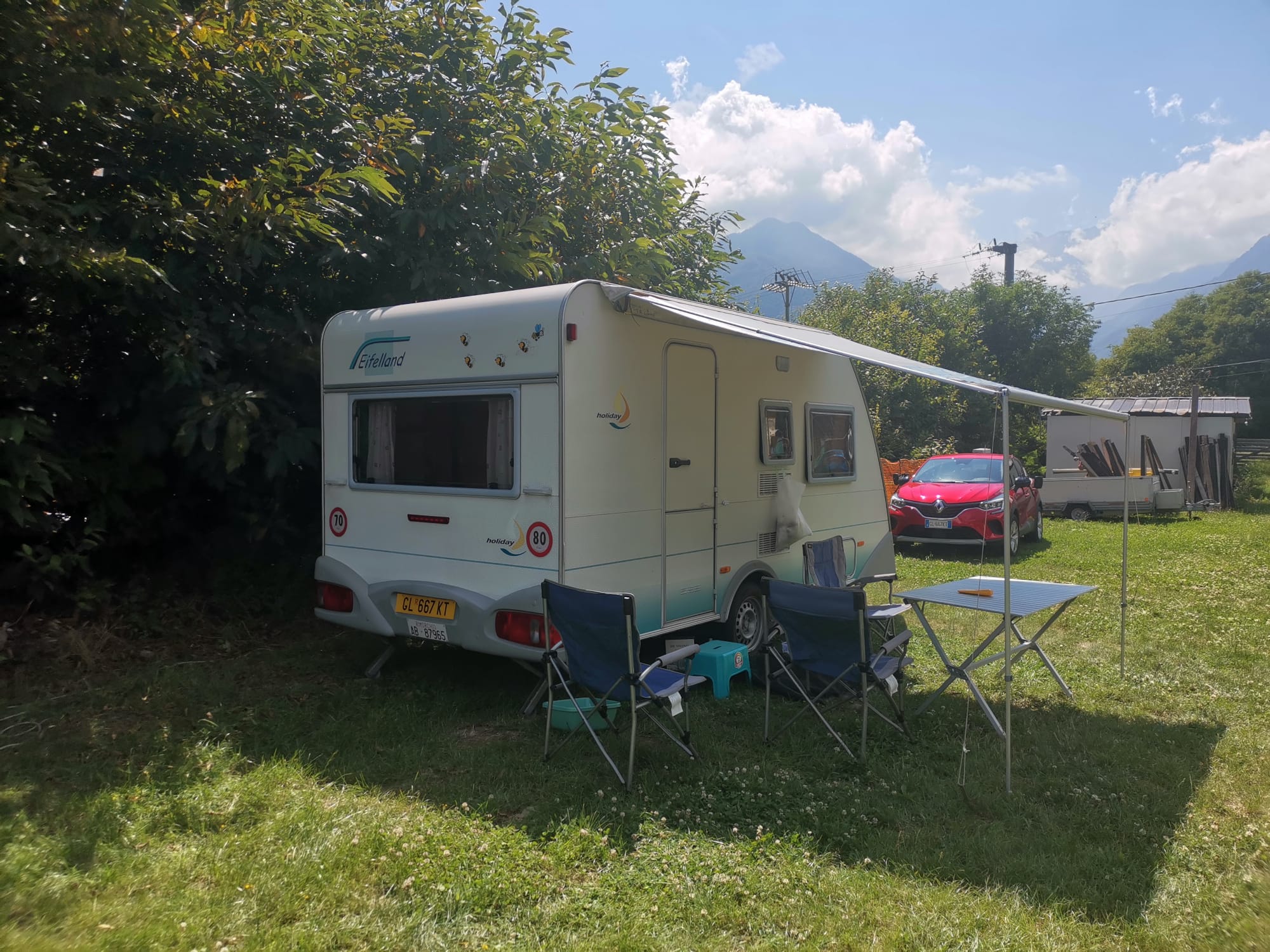 Camper parcheggiato in una piazzola erbosa con vista sulle montagne