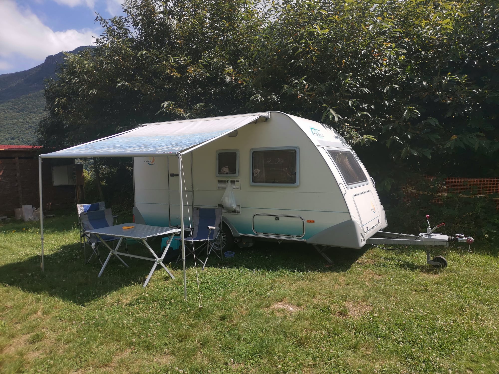 Caravan con veranda in una piazzola erbosa del Camping Valpellice